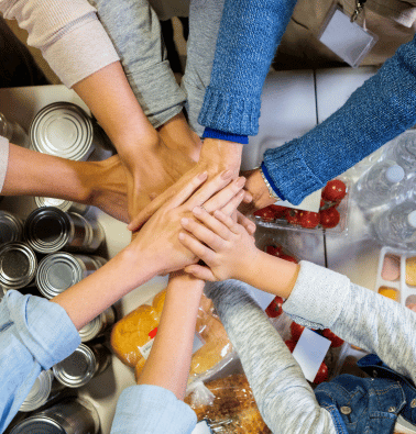 A picture of a team of hands over food items.